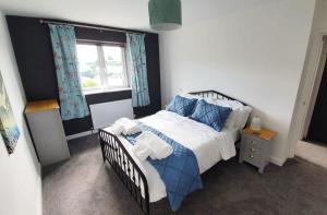 a bedroom with a bed with blue pillows and a window at The Mariners' Beacon Torquay in Torquay +28 photos