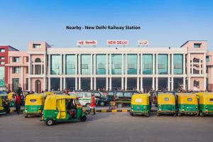 un aparcamiento con filas de vehículos pequeños frente a un edificio en OYO Pallvi Palace Paharganj Near New Delhi Railway Station, en Nueva Delhi