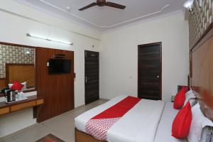 1 dormitorio con 1 cama grande con almohadas rojas en OYO Pallvi Palace Paharganj Near New Delhi Railway Station, en Nueva Delhi