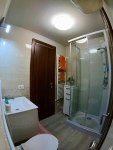 La salle de bains est pourvue d'une douche, de toilettes et d'un lavabo. dans l'établissement Amazing apartment two pool well located panoramic lake view, à Soiano del Lago