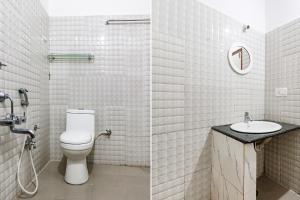a white bathroom with a toilet and a sink at FabHotel Raj Residency Madikeri in Madikeri