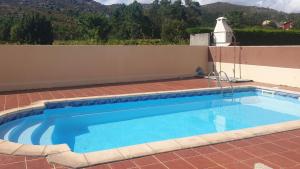 a swimming pool on a patio with a wall at Apartamento Ancora Caldebarcos in San Mamede de Carnota