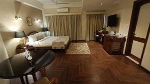 a hotel room with a bed and a desk at Hotel Polo Towers Shillong in Shillong