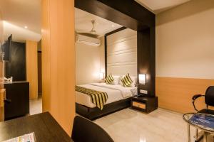 una camera d'albergo con un letto e un grande specchio di Capital O Hotel Konar Inn a Turambhe