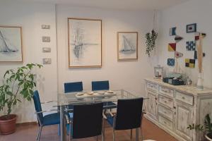 a dining room with a glass table and blue chairs at Costa Ballena Casa, pie playa y golf in Costa Ballena