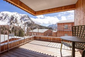 a balcony with a table and chairs and mountains at Almresort Sonnenalpe by ALPS RESORTS in Sonnenalpe Nassfeld