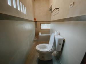 een badkamer met een toilet in een kleine kamer bij Country side room northern UBUD in Tegalalang