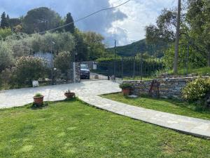 a garden with a stone wall and a driveway at Sunrise Holiday Home in Camogli