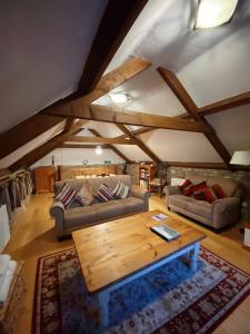 uma sala de estar com dois sofás e uma mesa de madeira em Idyllic Dartmoor Cottage em Postbridge