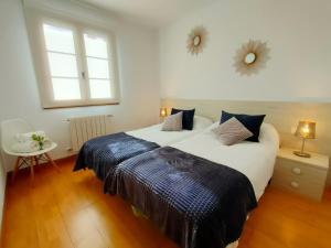- une chambre avec un grand lit et 2 fenêtres dans l'établissement Apartamento Baztan - Arraioz, à Arráyoz