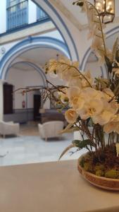a vase filled with white flowers on a table at Casa Palacio Don Pedro in Seville