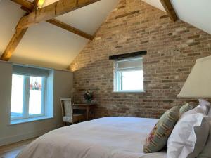 a bedroom with a brick wall and a bed at High End 3 bed barn conversion in Aller