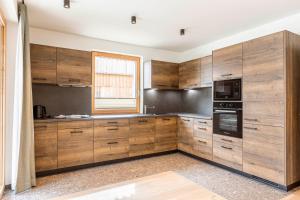 a kitchen with wooden cabinets and a window at Almresort Sonnenalpe Nassfeld in Sonnenalpe Nassfeld