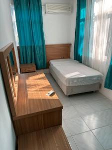 a bedroom with a bed and a table and a chair at ZÜMRÜT PANSİYON Side in Side
