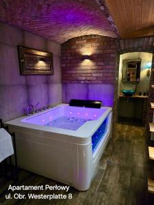 a large bath tub in a room with purple lighting at Sopot Spa Apartament in Sopot