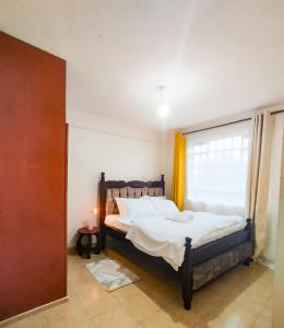 a bedroom with a bed and a large window at Cosy Homes Eldoret in Eldoret