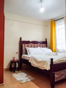 a bedroom with a large bed and a window at Cosy Homes Eldoret in Eldoret