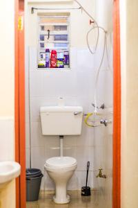 a small bathroom with a toilet and a window at Cosy Homes Eldoret in Eldoret