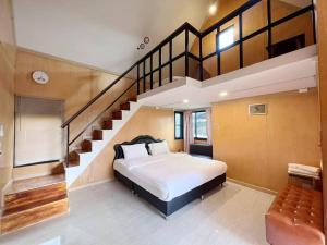 een slaapkamer met een groot bed en een trap bij The iNow ไอหนาว เขาค้อ in Phetchabun