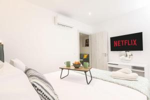a white room with a bed and a table at Arieni Places in Corfu +57 photos
