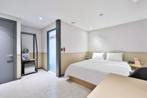 a bedroom with a large white bed and a window at No 25 Hotel Namyangju Bukhan River in Namyangju