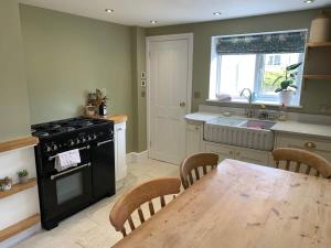 a kitchen with a wooden table and a stove top oven at Stunning Victorian Dartmoor House in Yelverton