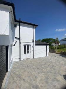 a white building with a driveway in front of it at Stunning Victorian Dartmoor House in Yelverton