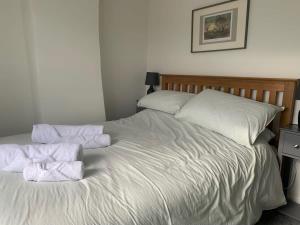1 cama con 2 toallas plegables encima en Stunning Hillside House, en Langport