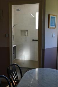 a glass shower door with a table and chairs at Jardin Madeleine in Morlaix
