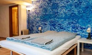 Nucleo di Intragna في إينتراغانا: سرير في غرفة ذات جدار ازرق