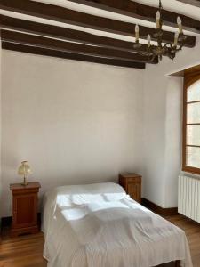 a bedroom with a white bed and a wooden ceiling at Domaine de la Haute-Porte in Souvigné-sur-Sarthe