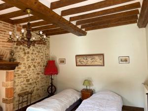 two beds in a room with a brick wall at Domaine de la Haute-Porte in Souvigné-sur-Sarthe