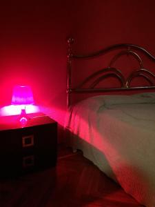 a bedroom with a bed with a pink lamp on a table at Via Spanish in Turin