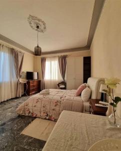 a hotel room with two beds and a desk at B&B Le rose di Paola in Santa Maria a Monte
