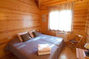 a bedroom with a bed in a log cabin at Cabana Coll Sisé in La Molina