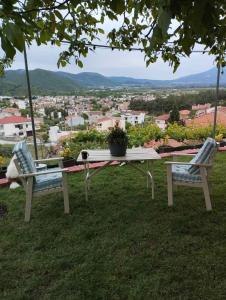 uma mesa de piquenique e duas cadeiras sentadas na relva em Hill House em Kavala