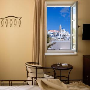 a bedroom with a window with a view of a city at Ikio Concept Santorini in Pyrgos