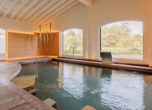 a swimming pool in a house with two windows at Fontsanta Hotel Thermal & Spa - Adults Only in Colònia de Sant Jordi