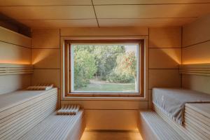 two beds in a room with a window at Fontsanta Hotel Thermal & Spa - Adults Only in Colònia de Sant Jordi