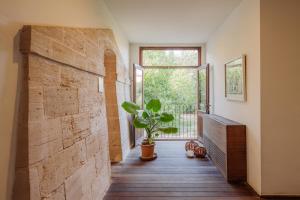 a hallway with a brick wall and a potted plant at Fontsanta Hotel Thermal & Spa - Adults Only in Colònia de Sant Jordi