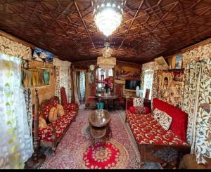 een woonkamer met rode meubels en een kroonluchter bij New Minar Group Of houseboats in Srinagar