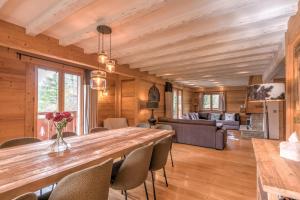a dining room with a large wooden table and chairs at Chalet Les Cimes - Welkeys in Praz-sur-Arly