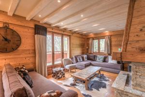 a living room with a couch and a fireplace at Chalet Les Cimes - Welkeys in Praz-sur-Arly