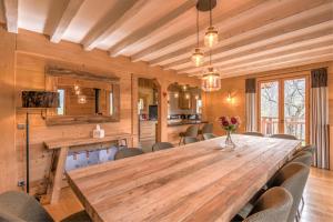 a dining room with a wooden table and chairs at Chalet Les Cimes - Welkeys in Praz-sur-Arly