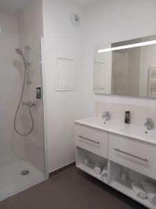 a white bathroom with a shower and a sink at All Suites Appart Hôtel - Le Havre Centre - Les docks in Le Havre