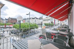 uma varanda de um restaurante com mesas e cadeiras em Hotel Saarlouis am kleinen Markt em Saarlouis