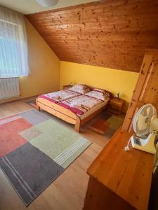 a bedroom with a bed and a wooden ceiling at Juhász Apartman in Gyenesdiás