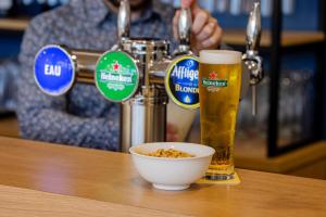 a table with a bowl of cereal and a glass of beer at All Suites Appart Hôtel - Le Havre Centre - Les docks in Le Havre