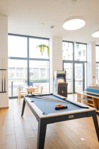 a living room with a pool table in a room at All Suites Appart Hotel Le Havre in Le Havre