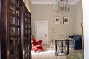 a dining room with a table and a chandelier at Palazzo Murat Luxury Rooms in Arienzo San Felice